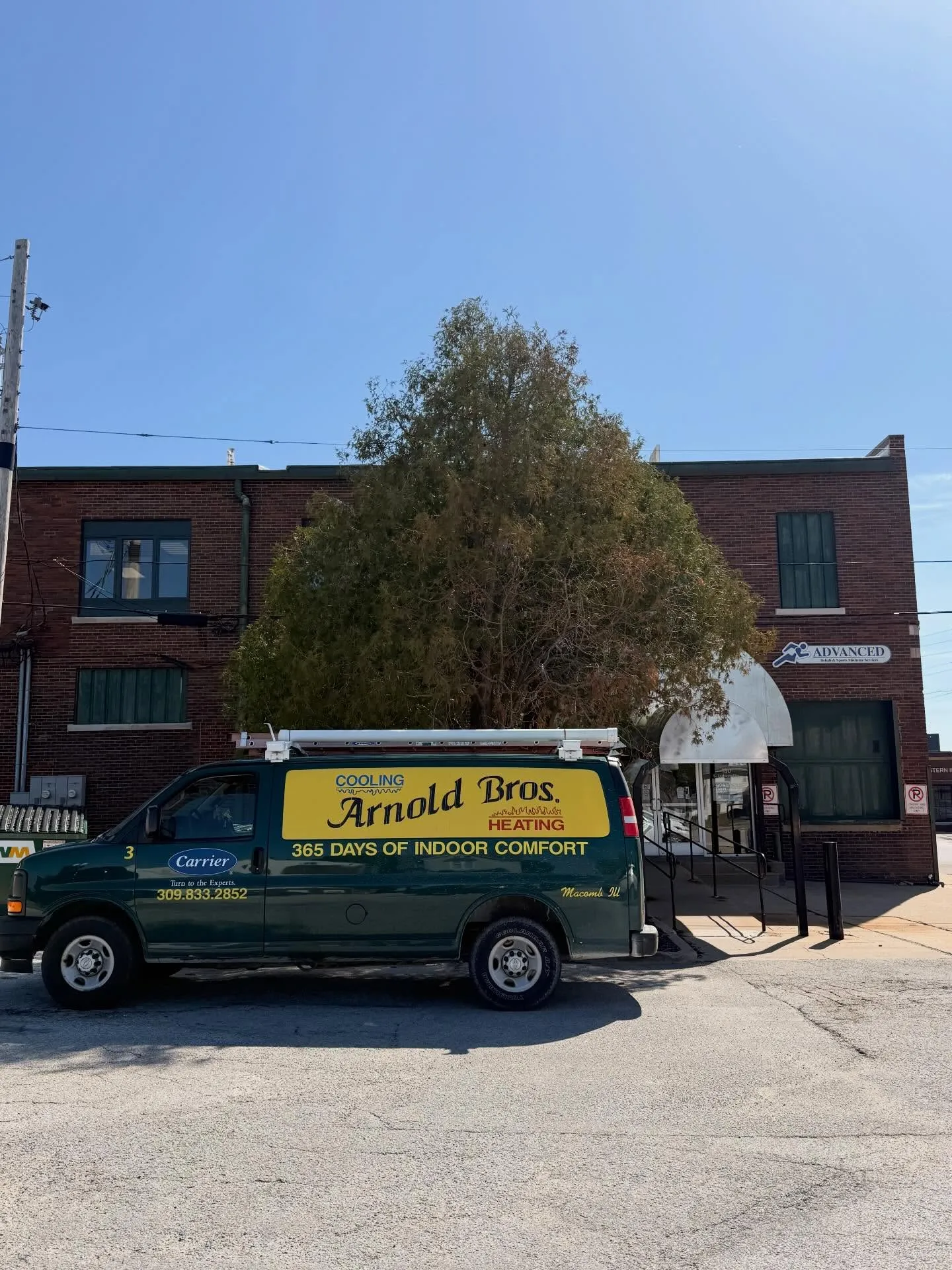 Arnold Bros. Heating & Cooling service van parked in front of the shop on West Jackson Street in Macomb, Illinois